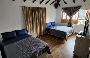 1 dormitorio con 2 camas y TV. en Hotel Niza Colonial, en Bogotá