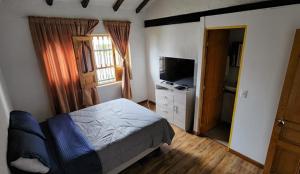1 dormitorio con 1 cama y TV en Hotel Niza Colonial, en Bogotá