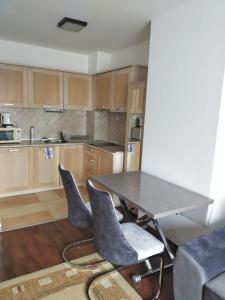 een keuken met een tafel en stoelen in een kamer bij Oksana's Apartment at Infinity in Bansko