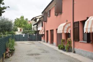 eine leere Gasse mit rosa Gebäuden und Sonnenschirmen in der Unterkunft Casa Emanuela, Il nostro Nido d'amore in Casalgrande