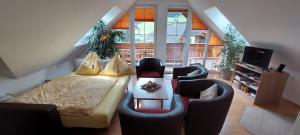 a living room with a bed and chairs and a television at Penthouse Aineckblick in Sankt Margarethen im Lungau