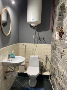 ein Badezimmer mit einem weißen WC und einem Waschbecken in der Unterkunft Gaudi apartment in Lviv in Lwiw