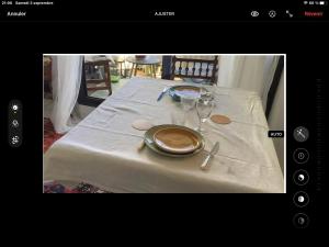 stół z talerzem na białym obrusie w obiekcie Appartement cosy la trinité sur mer w mieście Trinité-sur-Mer +1 zdjęcie