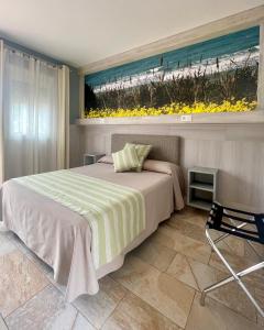 1 dormitorio con 1 cama y una pintura de la playa en Hostal Noli, en Chiclana de la Frontera