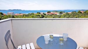 een tafel op een balkon met uitzicht op de oceaan bij Pakostane - VRGADA -appartement 50 m2 avec piscine in Pakoštane