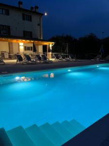 a swimming pool lit up at night at Apartments Colombara Bardolino in Bardolino
