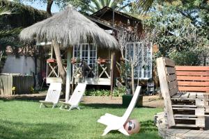 um grupo de cadeiras de jardim e uma cabana em Tinaja, Piscina, Cabaña, Quincho, Limache em Limache