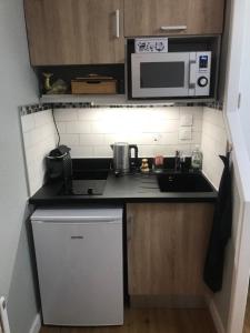 a small kitchen with a sink and a microwave at Brooklyn - Studio moderne à 2 pas du tram A in Grenoble
