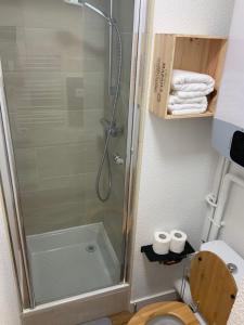 a bathroom with a shower and a toilet and towels at Brooklyn - Studio moderne à 2 pas du tram A in Grenoble