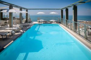 een zwembad met uitzicht op de oceaan bij Hotel Marco Polo in Caorle