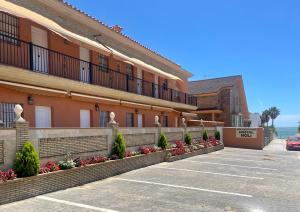 parking przed budynkiem z kwiatami w obiekcie Hostal Noli w mieście Chiclana de la Frontera