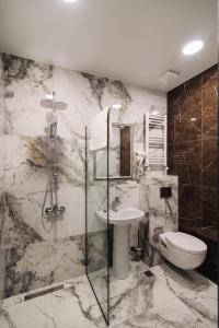 a bathroom with a toilet and a sink and a shower at Wine Rock Hotel in Tbilisi City