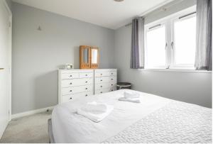 een witte slaapkamer met een bed en een dressoir bij Alltan at Culloden in Culloden