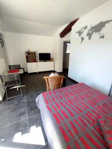 1 dormitorio con 1 cama y un mapa mundial en la pared en Studio R Homps en Homps