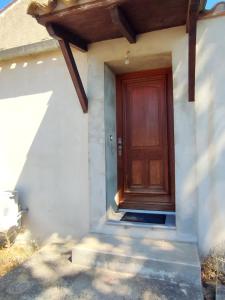 a brown door on a white house with stairs at Studio R Homps in Homps