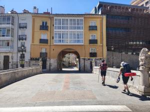 two people walking on a bridge in front of a building at Dúplex Centro Histórico in Burgos +6 photos