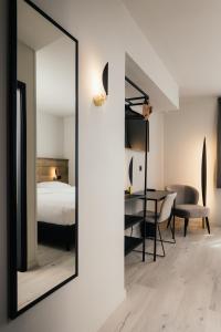espejo en un dormitorio con cama y mesa en Hotel Au lit des ours en Han-sur-Lesse