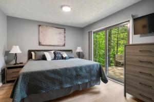 哈伯斯普林斯Harbor Springs-Secluded setting+amenities+pets的一间卧室，里面有一张床和一扇大窗户。 更多33张照片