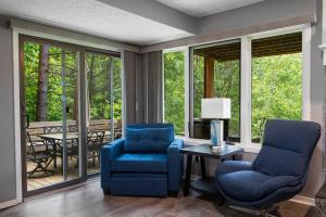 哈伯斯普林斯Harbor Springs-Secluded setting+amenities+pets的客厅配有两把椅子和一张桌子,窗户