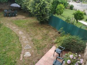 um jardim com dois bancos e uma mesa com um guarda-sol em Casas las Carolinas em Anaz