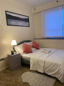 a bedroom with two beds and a lamp and a window at Luxury Apartment in Woolwich Arsenal in Woolwich