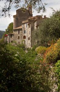 un vecchio edificio con una torre in cima a una collina di Mas Thomasine Séjour Romantique au calme a Peillon