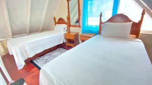 1 dormitorio con 2 camas y ventana en Oceanfront Condo w/ FREE Parking + High Speed Wifi, en Negril