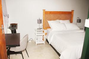 1 Schlafzimmer mit einem Bett und einem Schreibtisch sowie einem Bett der Marke sidx sidx sidx. in der Unterkunft Adorable 1.5 -Bedroom flatlet in Germiston in Germiston