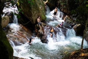 a group of people playing in a waterfall at BOSQUE EL DESCANSO in Jamundí