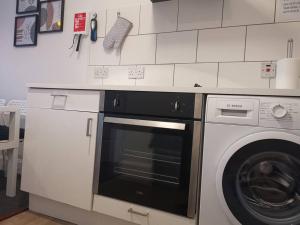 a kitchen with a dishwasher and a washing machine at Castleview is a lovely flat in a listed building in Rothesay