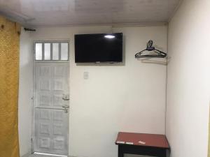 a flat screen tv on a wall next to a door at Hotel Casa Nini in Bogotá