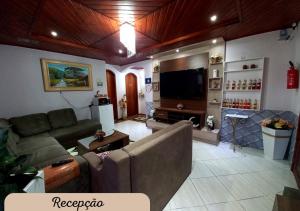 a living room with a couch and a flat screen tv at Hospedagem Alternativa Família Martins in Urubici