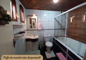 a bathroom with a toilet and a sink and a tub at Hospedagem Alternativa Família Martins in Urubici