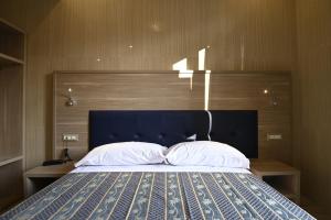 une chambre avec un grand lit et une tête de lit bleue dans l'établissement Hotel Midway, à Milan