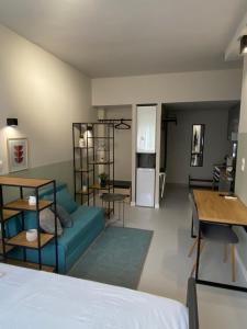 a living room with a blue couch and a kitchen at E2G URBAN STAY #G in Thessaloniki