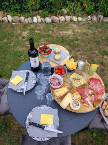 a blue table with food and a bottle of wine at Chambre avec jacuzzi privatif "le pêcher" in Saillans
