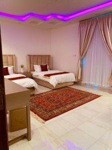 a bedroom with two beds and a purple ceiling at شقق الروشن الجوفي in Al Fayşalīyah