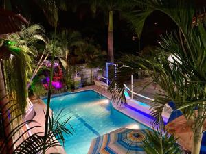 a swimming pool at night with palm trees and lights at CABAÑAS ECOLOGICAS STEPHANIE JIRETH in Tonsupa