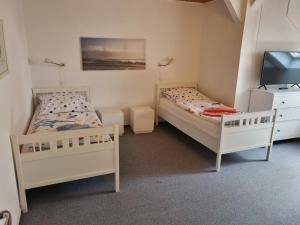 two beds in a small room with a tv at "Ferienhaus Vadersdorf" Wohnung 1 in Vadersdorf