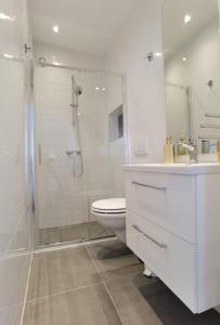 Apartment Emma في بريكو: حمام أبيض مع دش ومرحاض