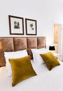 ein Schlafzimmer mit einem weißen Bett und gelben Kissen in der Unterkunft Apartment Emma in Preko