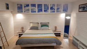 a bedroom with a bed with pillows on it at Le T-Top in La Trinité-sur-Mer