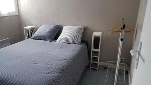 a bedroom with a bed with two blue and white pillows at Le T-Top in La Trinité-sur-Mer