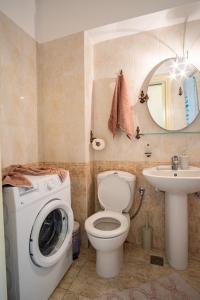 uma casa de banho com uma máquina de lavar roupa e um lavatório em Erifili Luxury Apartment em Samos