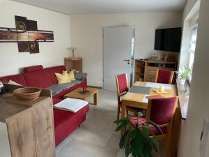 a living room with a red couch and a table at Ferienwohnung Arthur in Luckenwalde