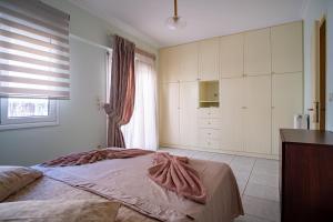 um quarto com uma cama grande e uma janela em Erifili Luxury Apartment em Samos
