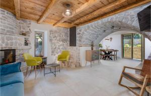 a living room with a stone wall at Pet Friendly Home In Malinska With Outdoor Swimming Pool in Malinska