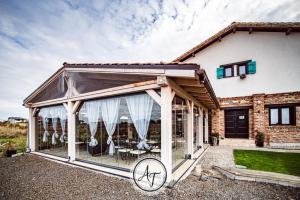 a conservatory with awning in front of a house at ANTICA RESIDENZA TOSCANA in Dumbrăviţa