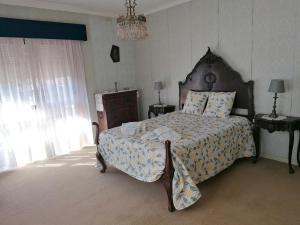 a bedroom with a large bed and a chandelier at CLE House in Anadia