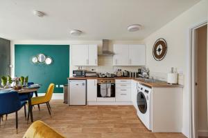 a kitchen with white appliances and a table with chairs at 30 percent OFF! Emerald 3 Bed Gem in Southampton in Totton